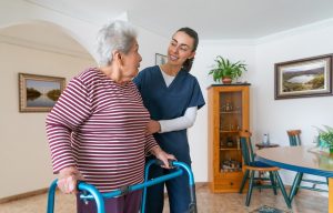 Caregiver helping senior in walker.