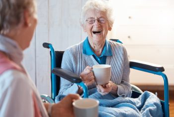 Two senior women enjoy spending time together thanks to senior companion care in facilities.