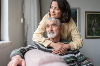 A woman considers personalized senior care support as she moves her elderly father into an assisted living facility.