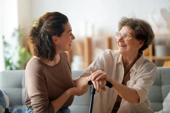 An older adult and adult daughter talk comfortably together while discussing early home care support options.