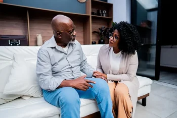 A woman talks with her father while introducing home care services in a way that will hopefully make him less defensive.